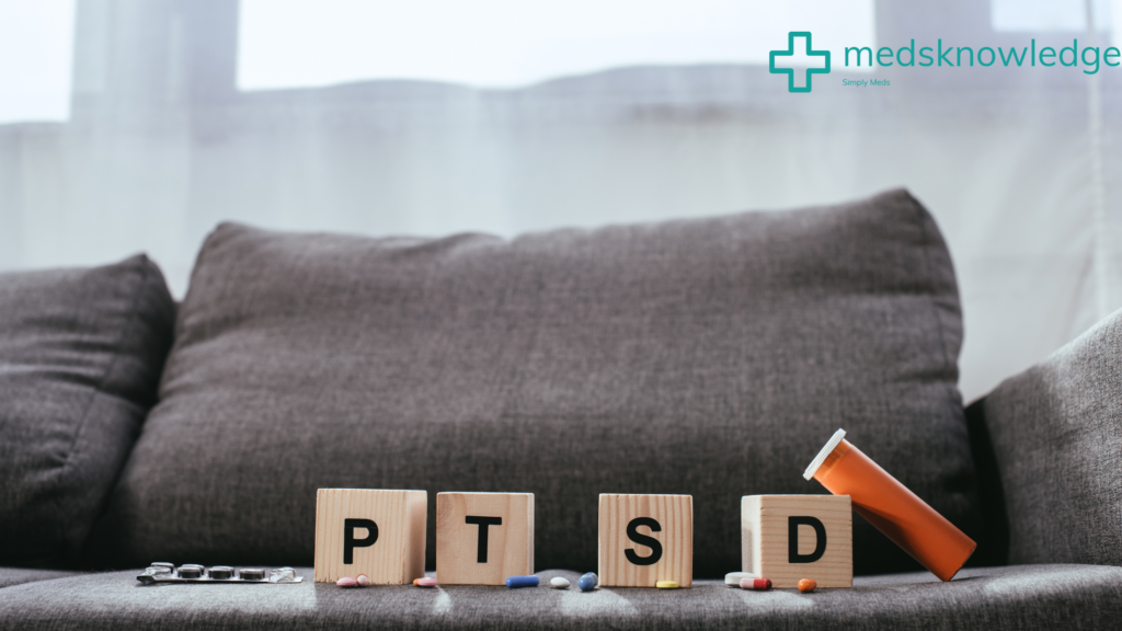 Wooden blocks spelling out 'PTSD' with scattered pills and a prescription bottle on a gray couch, symbolizing the treatment of Post-Traumatic Stress Disorder.