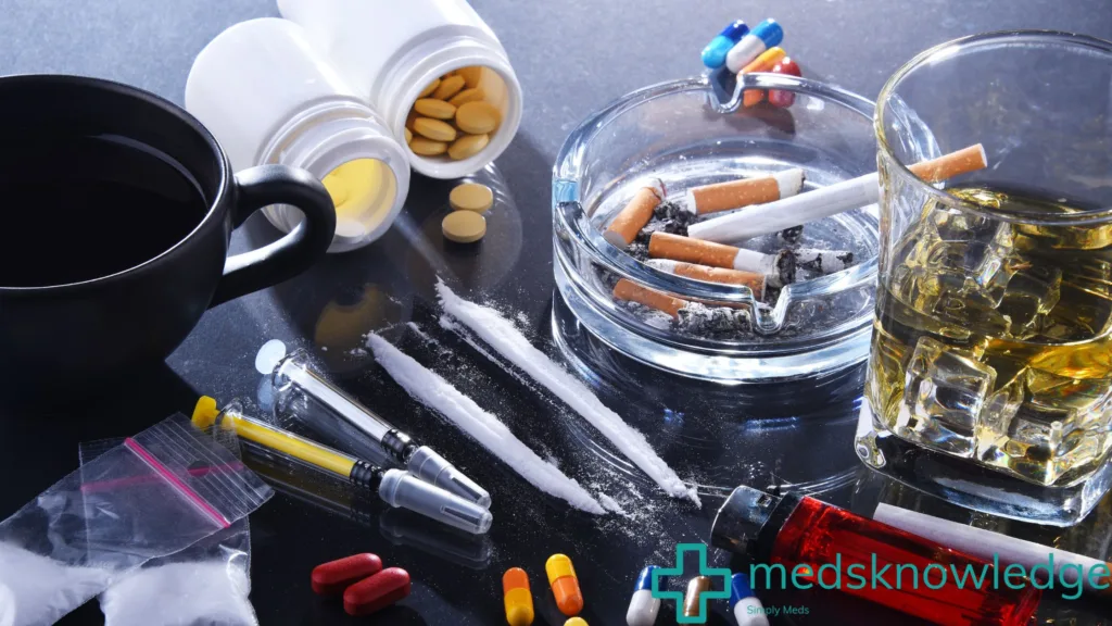 Various substances and paraphernalia associated with substance use disorder on a dark surface.